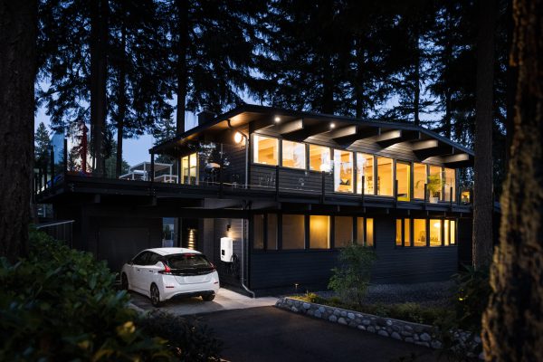 Car charging at home at dusk. Electric vehicle home charging reimbursement is easier with Paua Reimburse.
